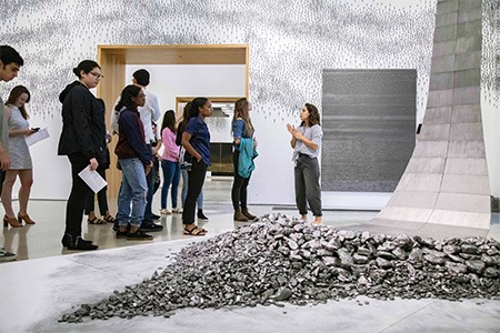 woman guide leading group in museum