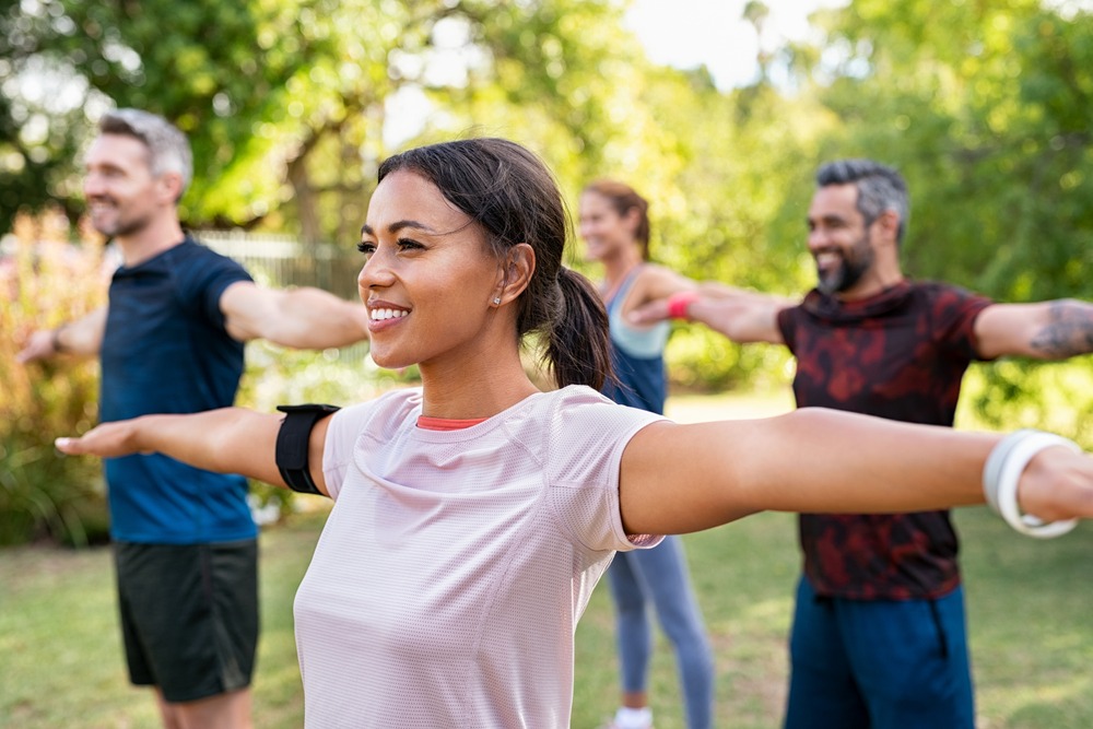 group of people stretching arms outside