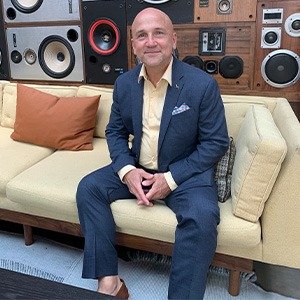 man sitting down in from of speakers
