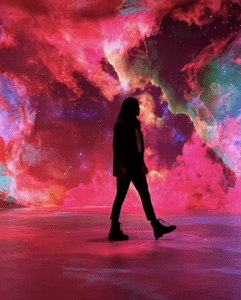 silhouetted person walking against pink background