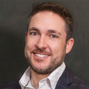 man wearing white dress shirt and dark blue plaid coat