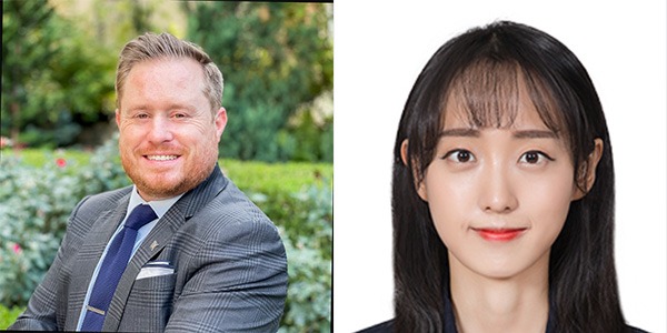 man on left wearing suit, woman on right wearing black top