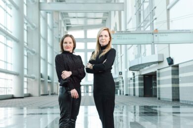 two women standing in convention center foyer