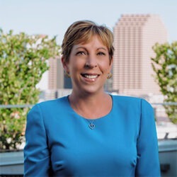 woman in long sleeve blue shirt smiling