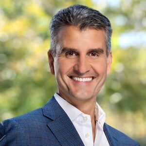 man in blue sport coat and white dress shirt smiling