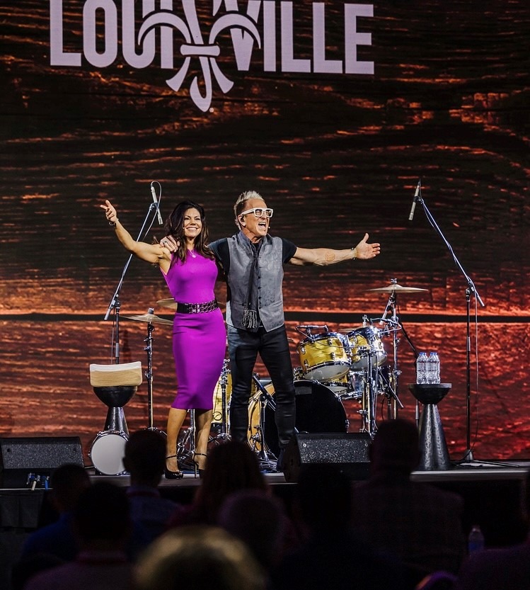 two people on stage with arms outstretched
