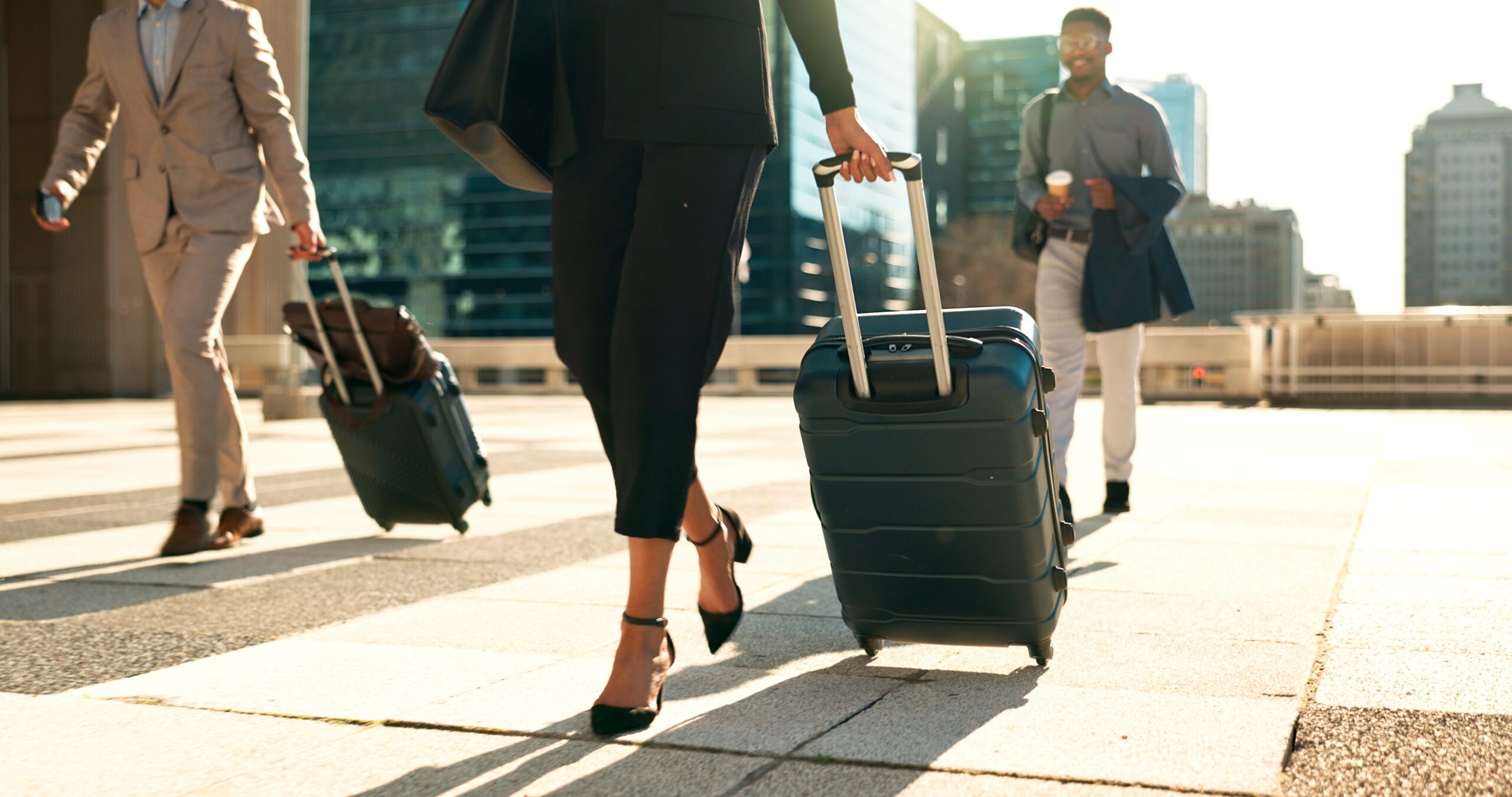 three businesspeople traveling with luggage