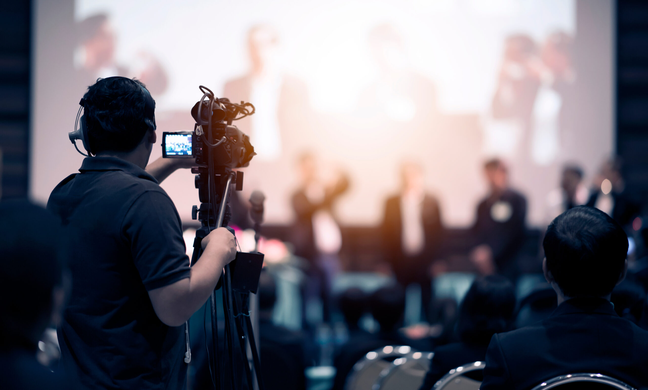 Video camera operator working with his equipment at indoor event