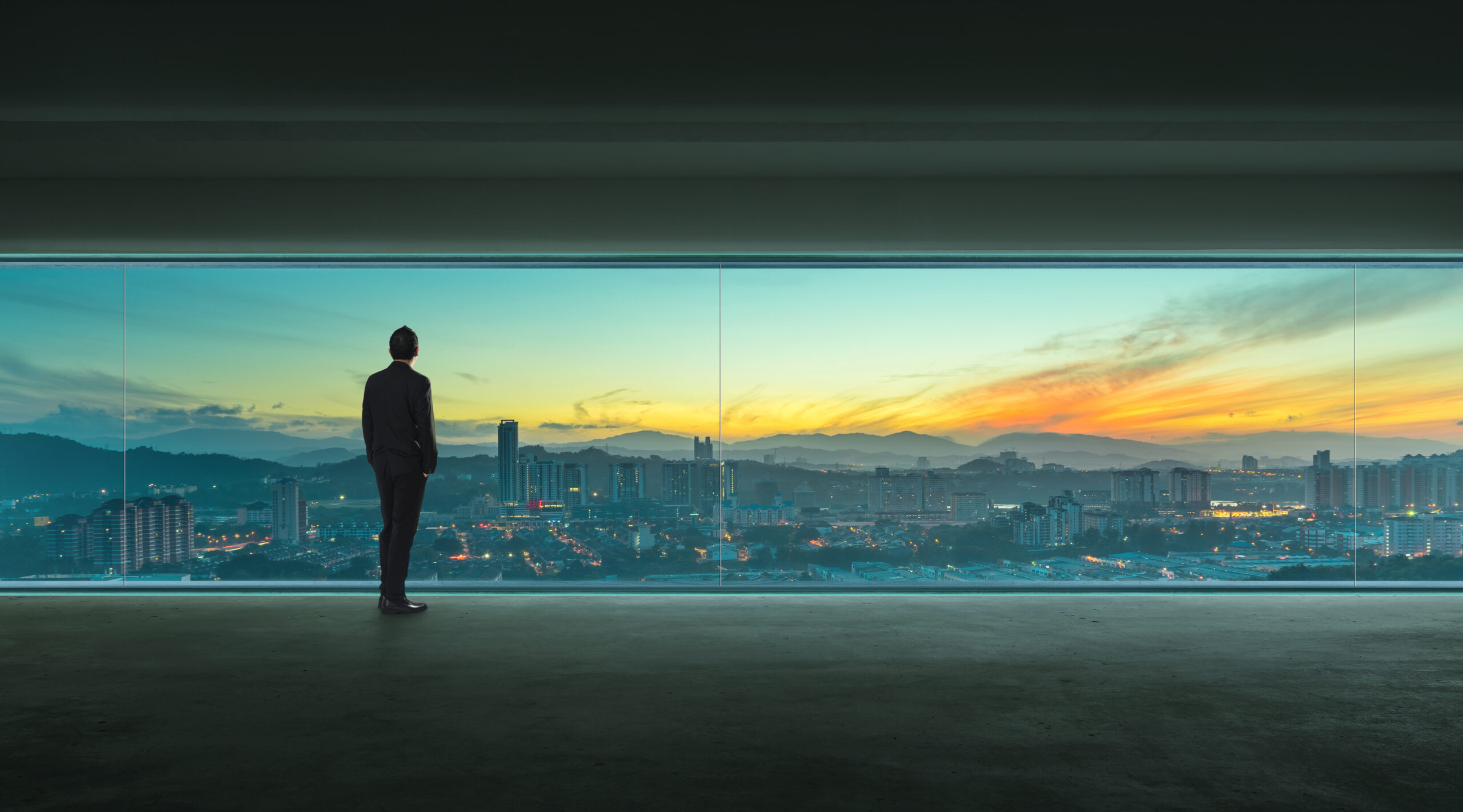 businessman looking at the city from his office