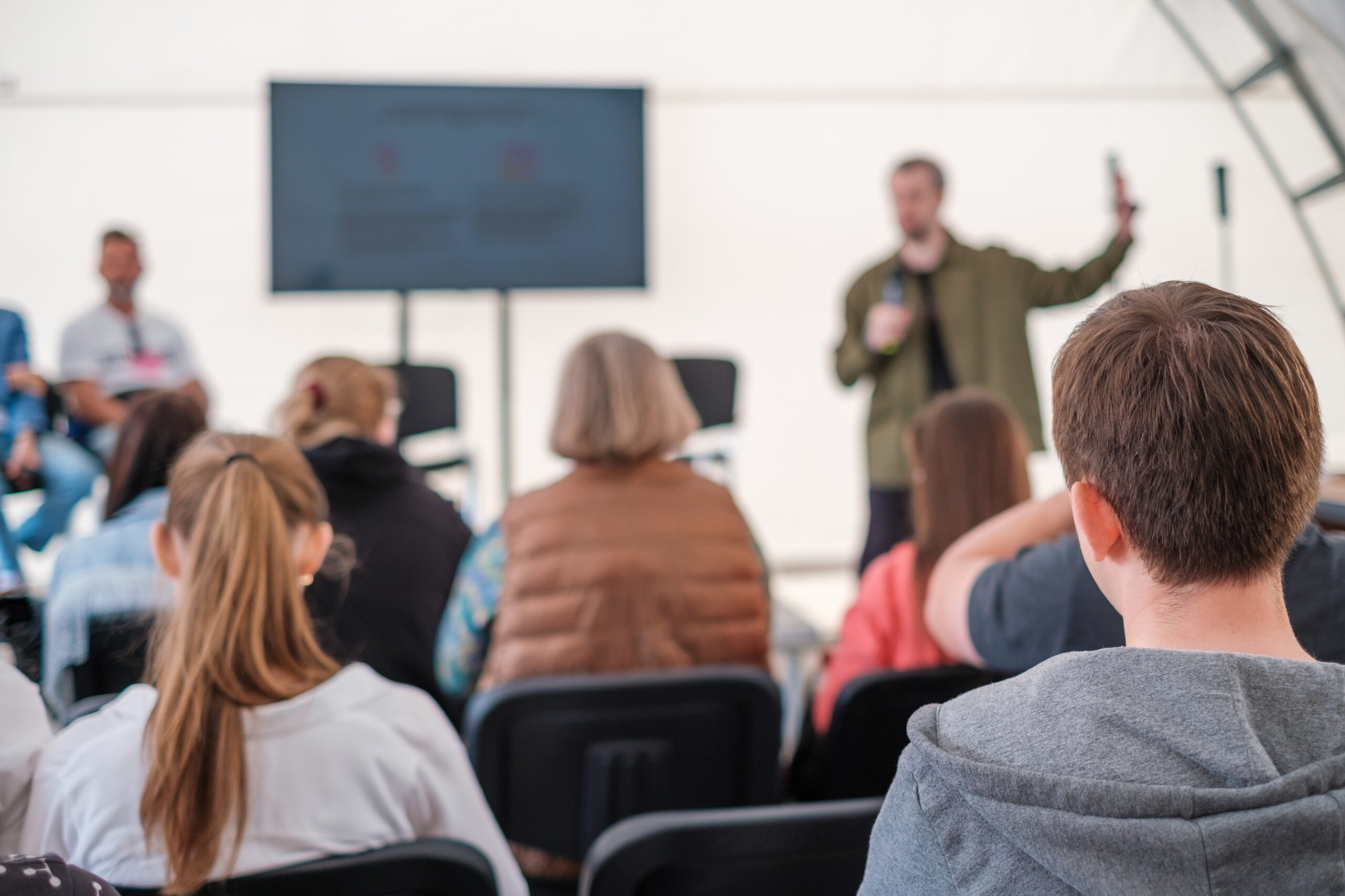 Engaged audience listening to a presenter at an informal outdoor event
