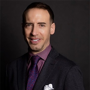 James Sheets in purple dress shirt and tie, and black sport coat