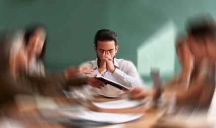 Man sitting in meeting room experiencing anxiety