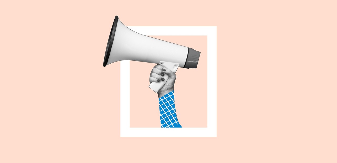 Hand holding microphone against pink background