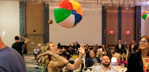 Woman hitting beach ball in conference room