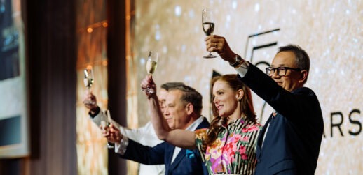 Four people holding up champagne glasses