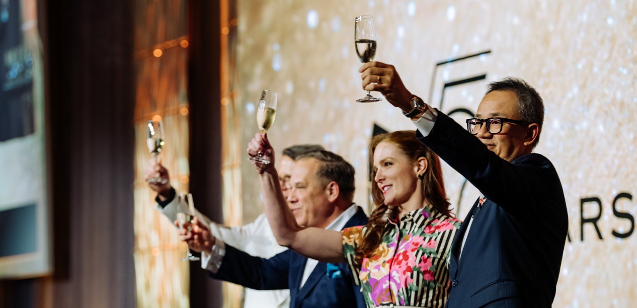 Four people holding up champagne glasses