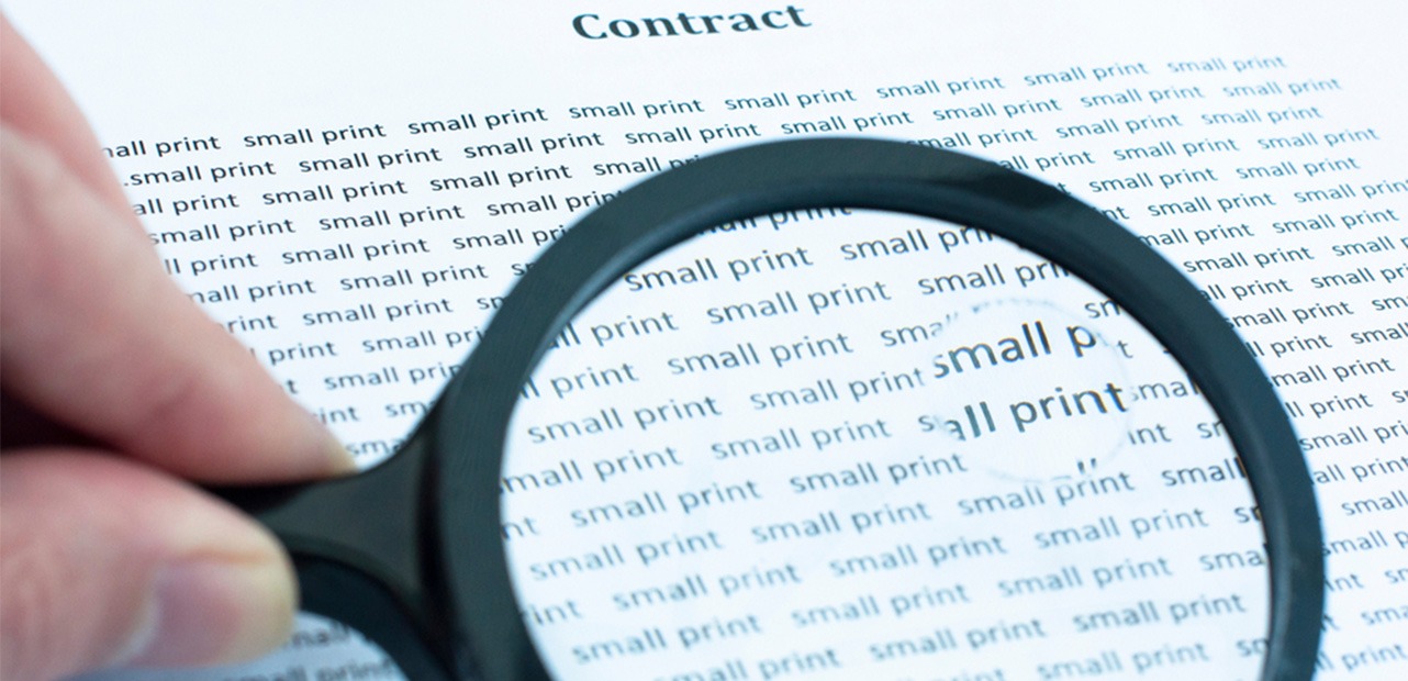 Magnifying glass looking at words "small print"