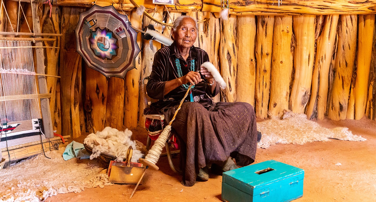 A Navajo woman demonstrates weavingat Monument Valley