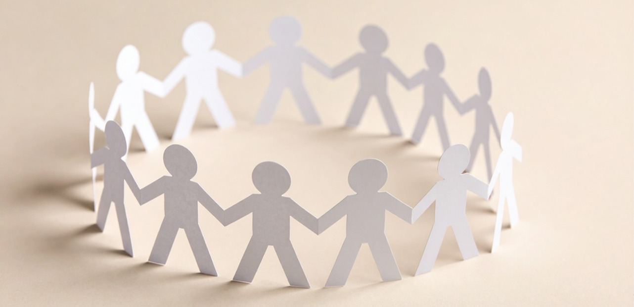 Paper cutouts of people holding hands in circle
