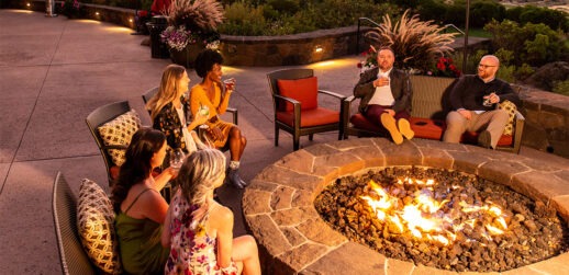 Coworkers sitting around fire pit at Tetherow Resort