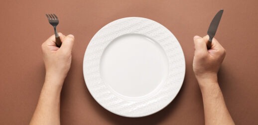 Person sitting in front of empty plate