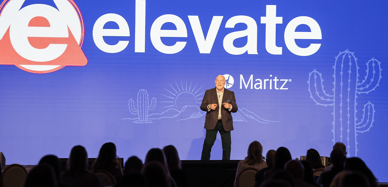 Greg Bogue on stage in front of Elevate signage