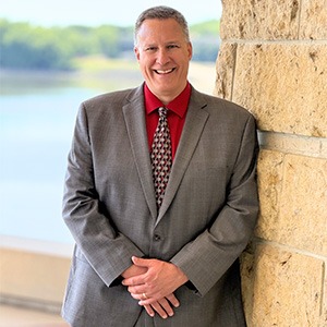 Scott Hallgreen wearing grey suit and red shirt