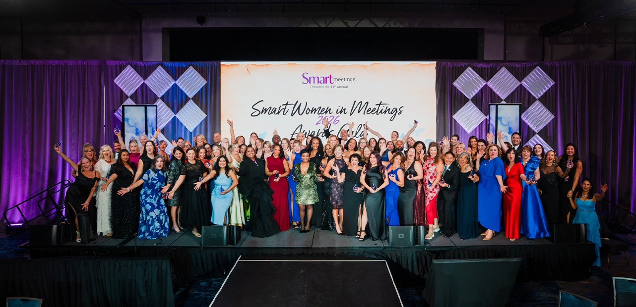 Women posing in front of Smart Woman Summit 2026 logo