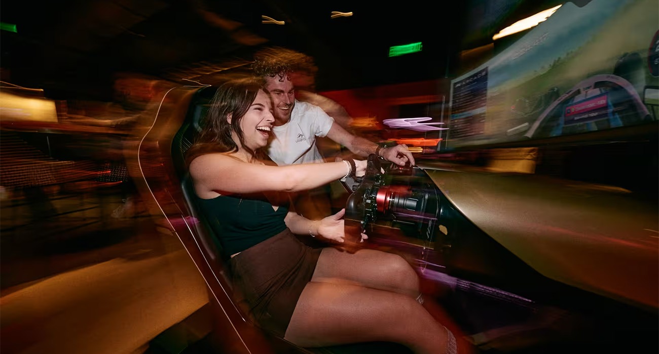 Two people on playing F1 car simulator