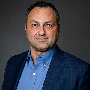 Richie Karaburun wearing blue suit with no tie