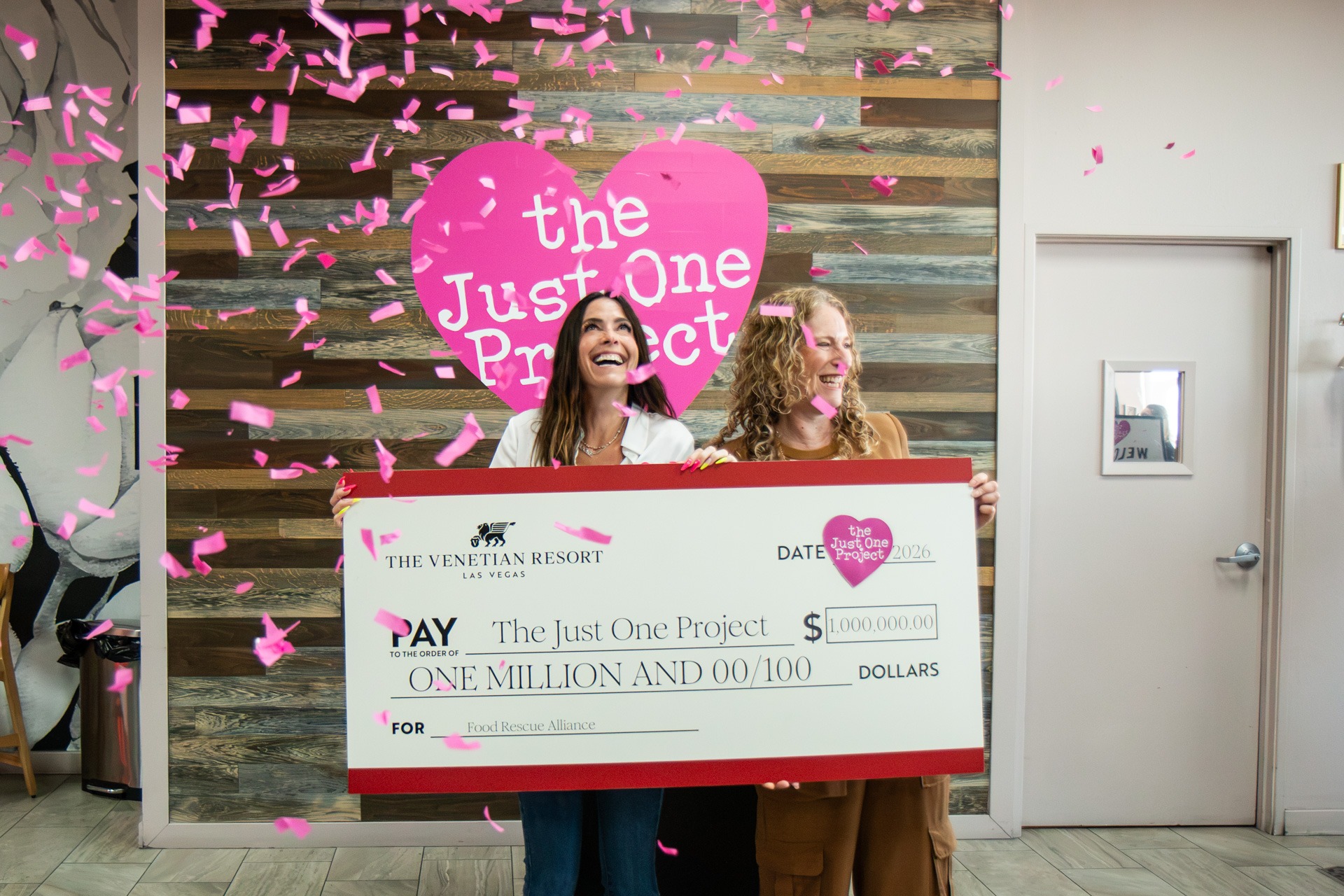 Two women holding large check