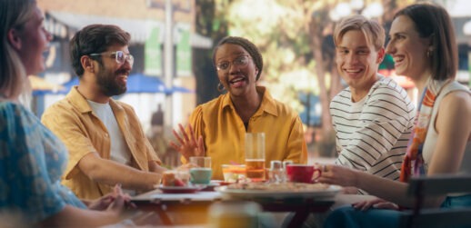 Group of five friends talking at table
