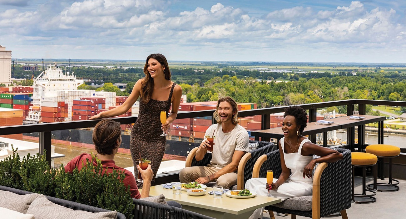 Four people talking at rooftop bar